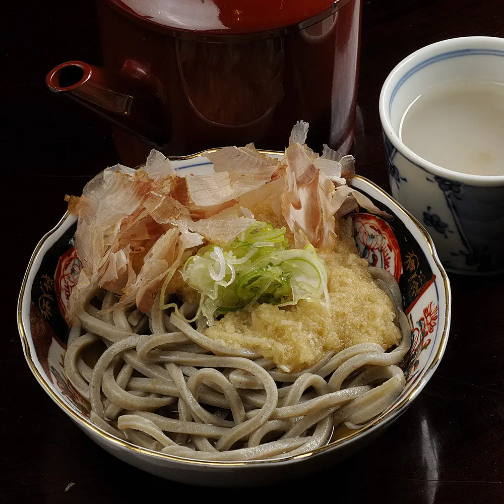 The Echizen Oroshi Soba, made with Ni-hachi soba (80% buckwheat, 20% wheat flour), offers a perfect balance of smooth texture and firm bite, complemented by the refreshing zest of grated daikon radish.