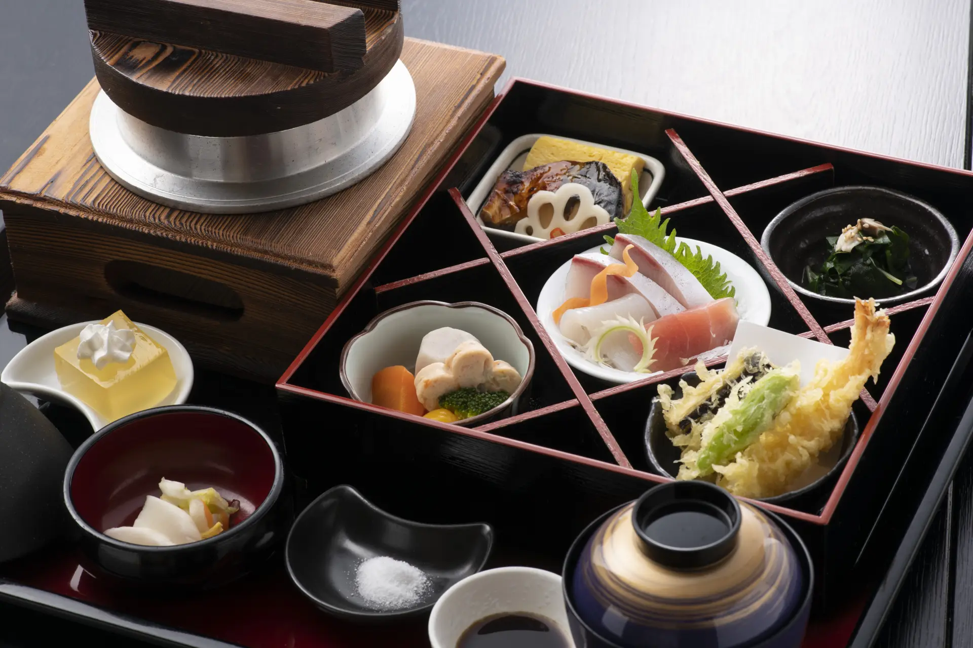 The Kamameshi Lunch Set features a mountain vegetable kamameshi (rice cooked in an iron pot), accompanied by sashimi and tempura, offering a delightful taste of seasonal flavors.