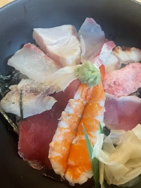 A seafood rice bowl topped with around ten different ingredients