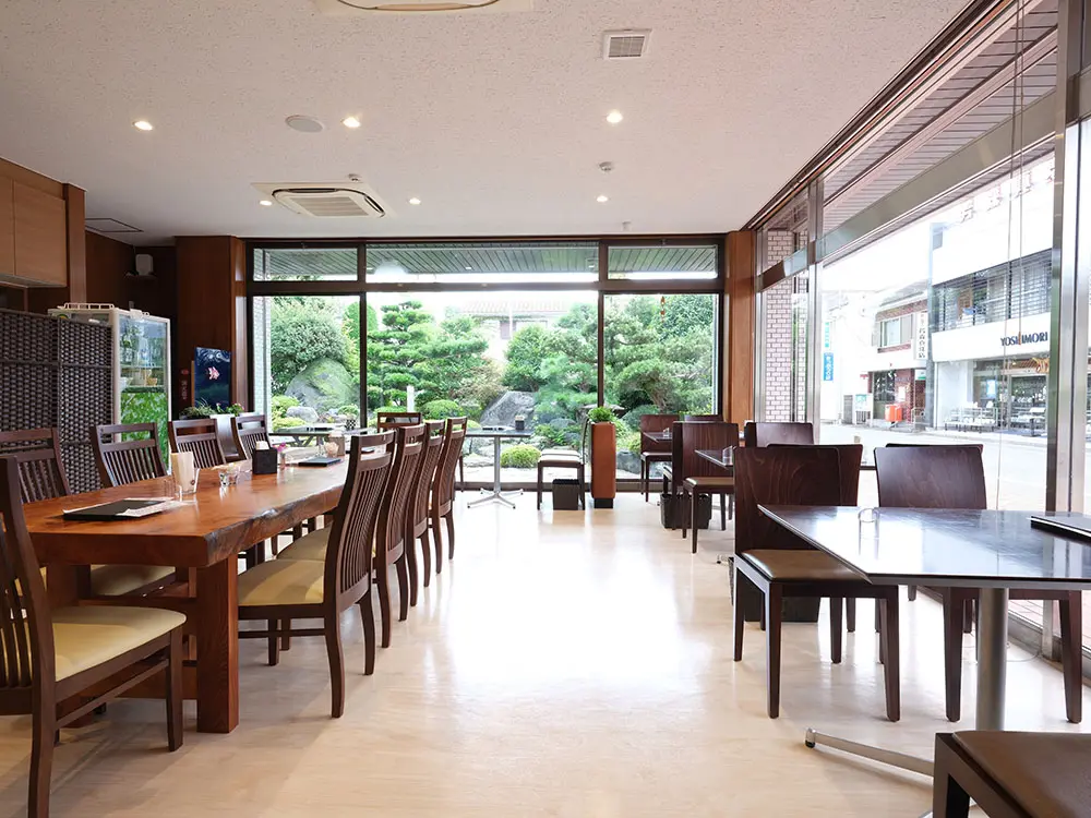 The café, integrated within the store, offers a serene atmosphere with a beautiful Japanese garden visible through the windows, enhancing the dining experience.