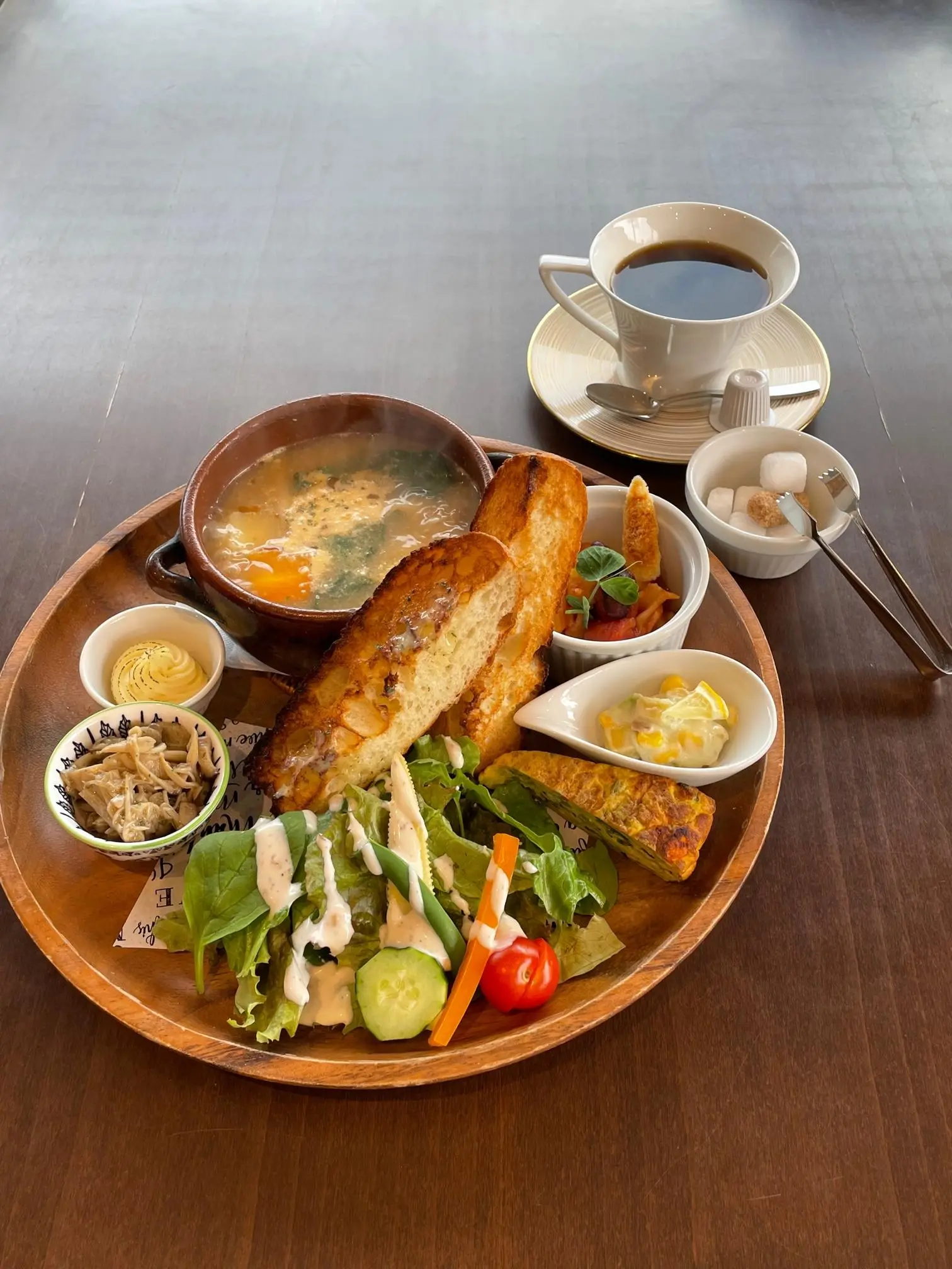 The Iwajin-style Bouillabaisse Lunch is beautifully presented on a single plate, featuring bread and a rich, flavorful soup, creating a delightful and satisfying meal.