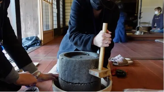 Using an old-fashioned stone mill as a coffee grinder. The effort put into grinding makes the coffee taste all the more special.